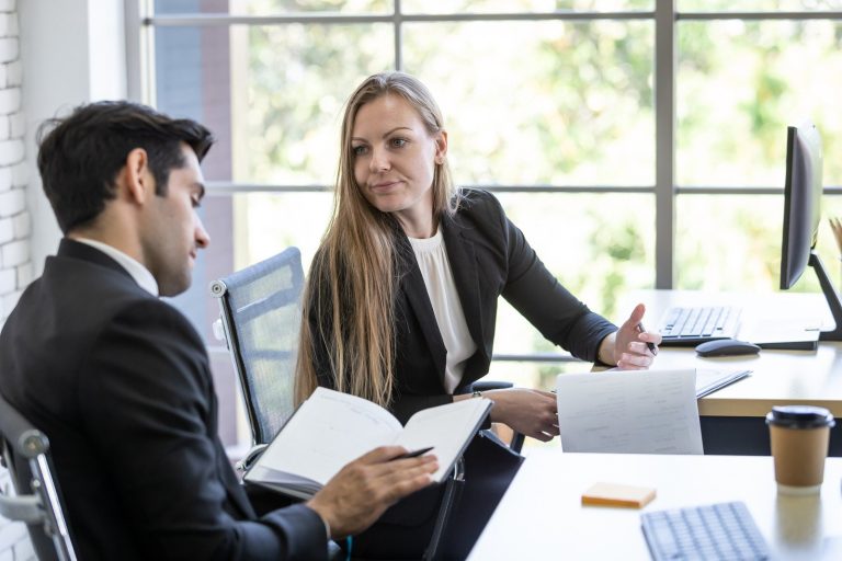 a man looking over a will with a woman in a conference room during the day