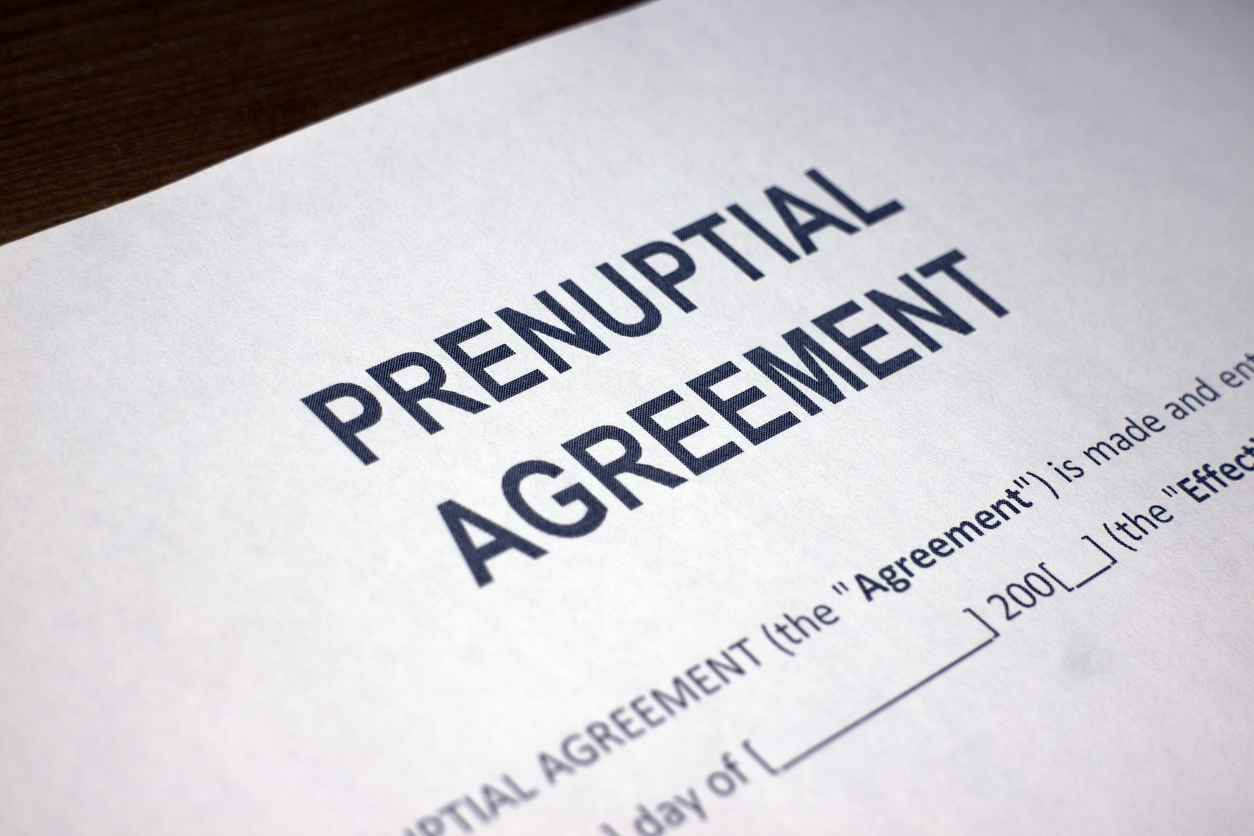Close-up of a "Prenuptial Agreement" document with bold text on a white page, suggesting legal or contractual preparation before marriage.