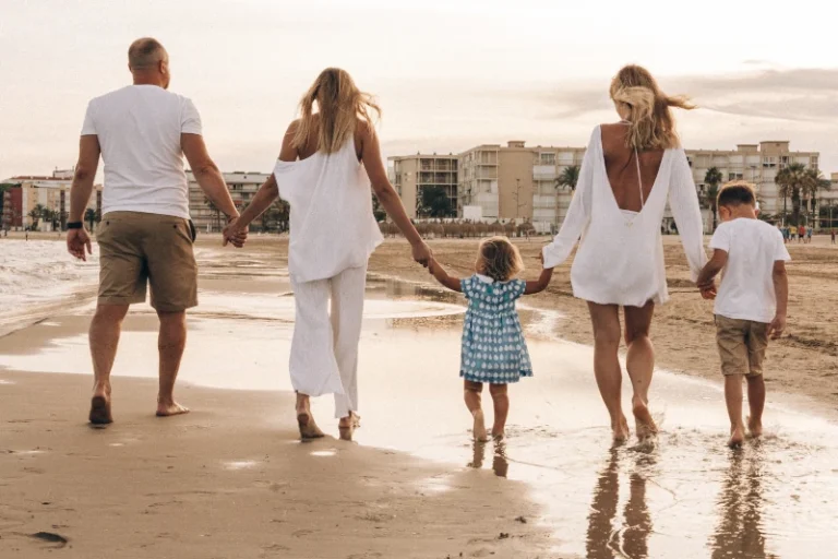 A blended family of five walking hand-in-hand along a sunny beach, representing the importance of protecting inheritance in a second marriage in Colorado, as featured in the image "Protecting Inheritance in a Second Marriage in Colorado featured image.webp".